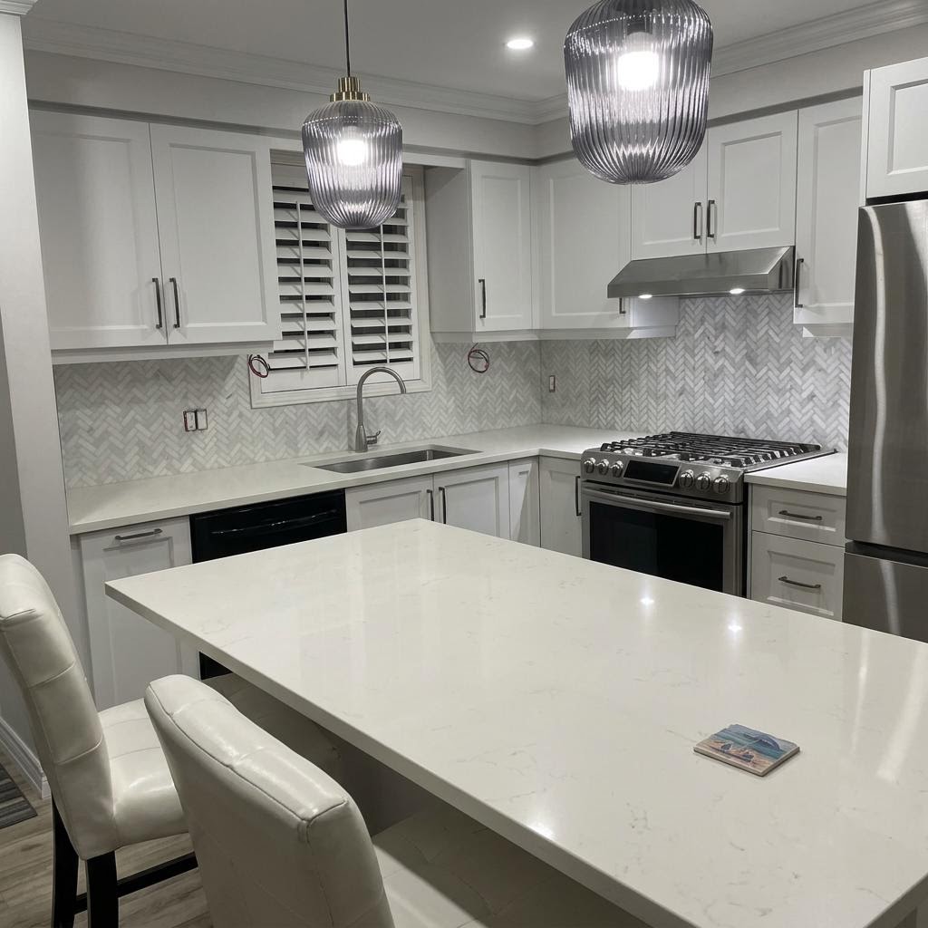 Kitchen after full renovation — quartz island, pendant lights, herringbone backsplash