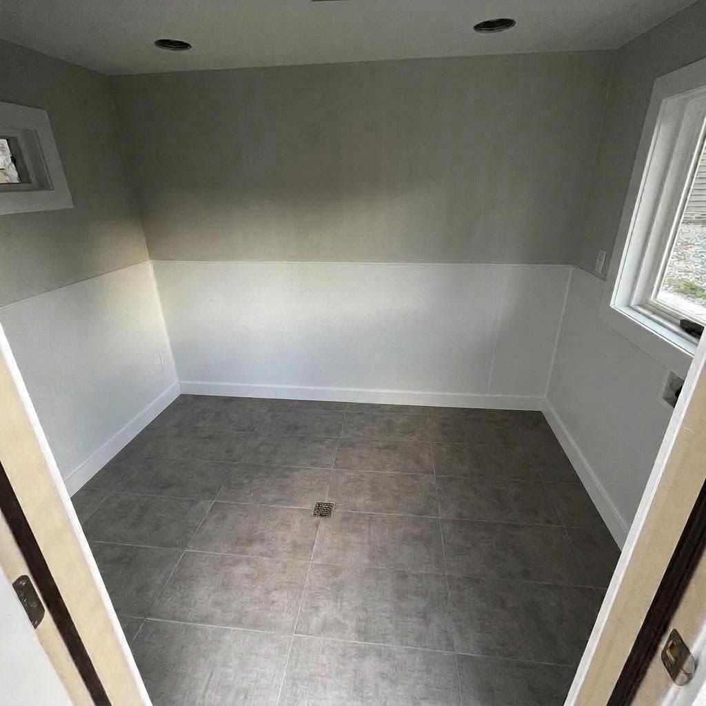 Room after renovation — drywalled, painted, and tiled